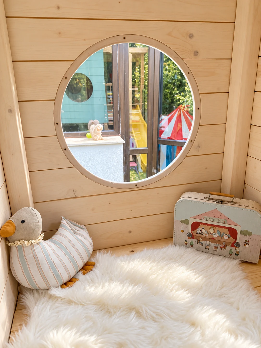 Cosy nook beneath a round window inside the timber-lined playhouse